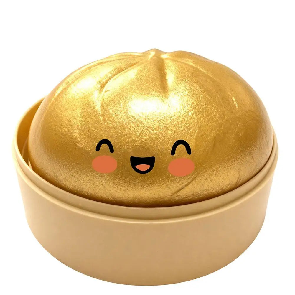 Shiny gold squishy bun stress ball in beige round case, smiling face with rosy cheeks