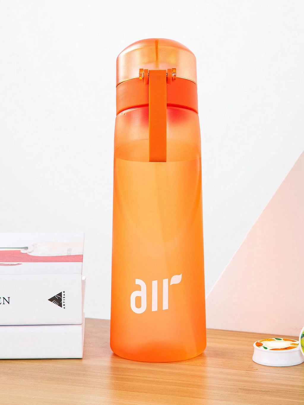 Orange air water bottle with translucent body, flip top lid, and carry handle