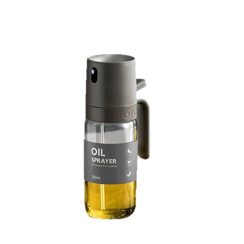 Clear glass oil sprayer bottle with dark metal top and side handle