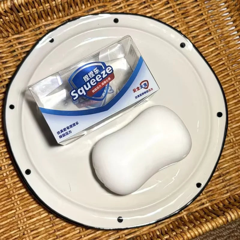 White squishy toy placed on a round dish on a woven surface.
