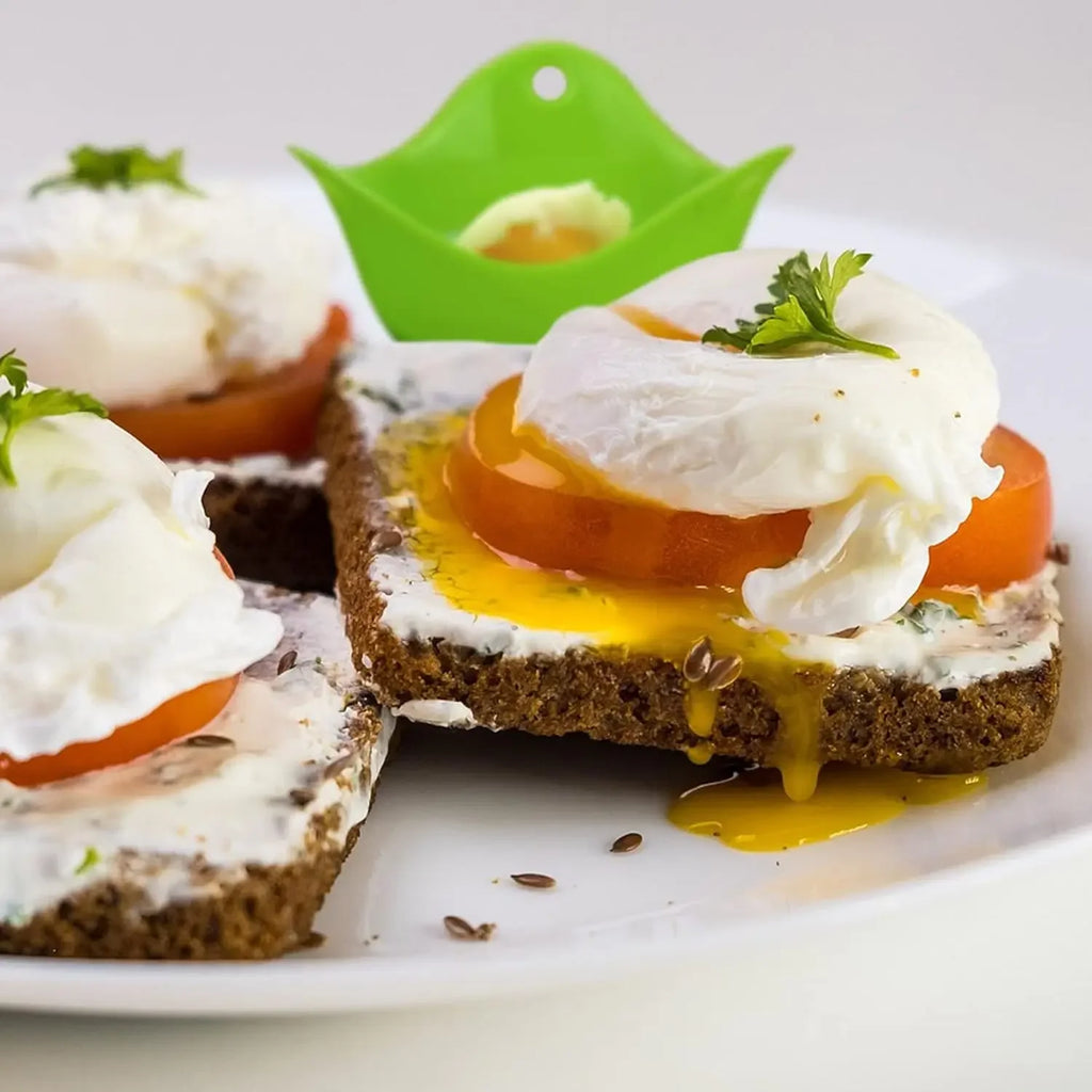 Green silicone egg poacher cup with poached egg on toast.