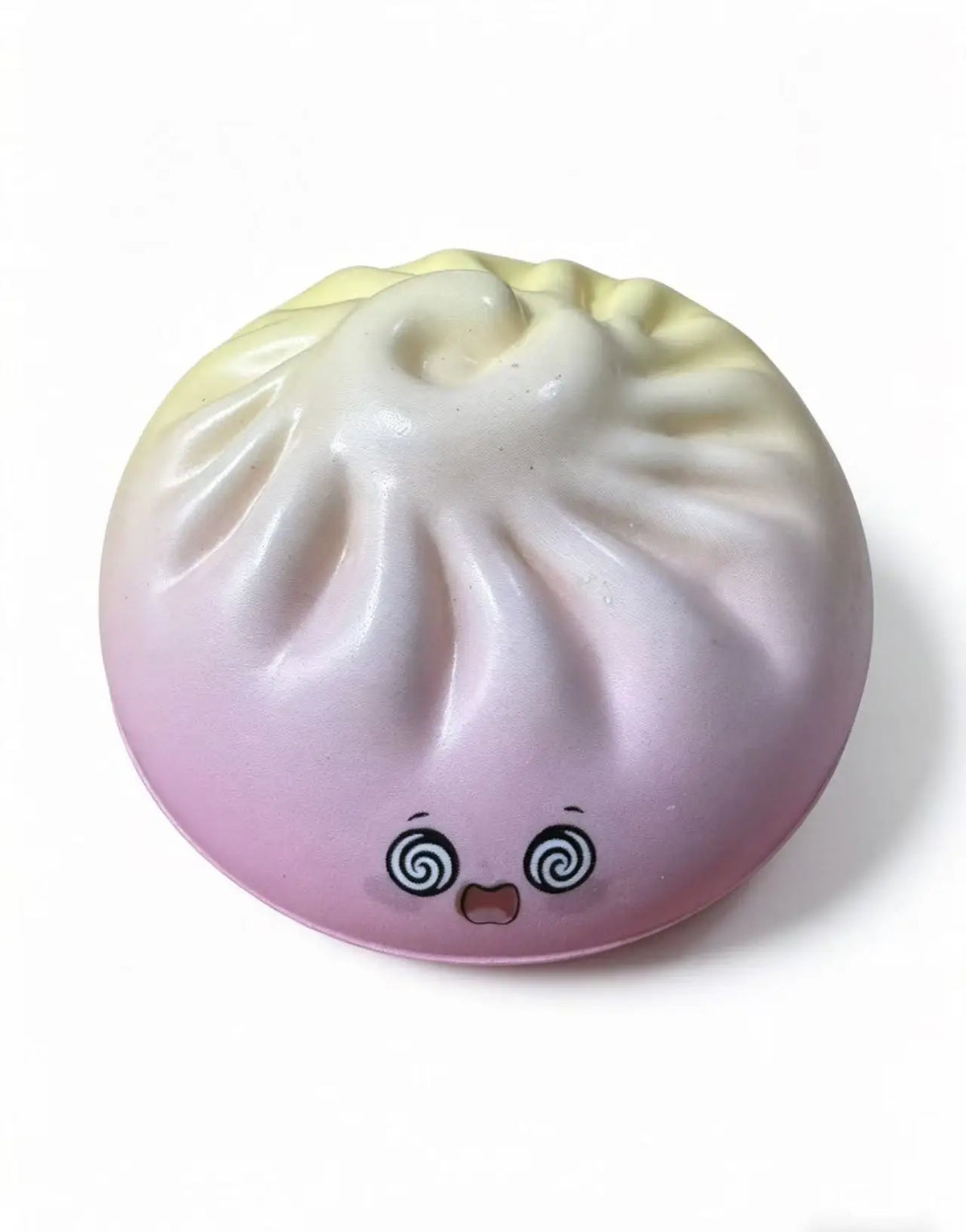 Pastel dumpling squishy toy with spiral cheeks, closed eyes, and ribbed texture.