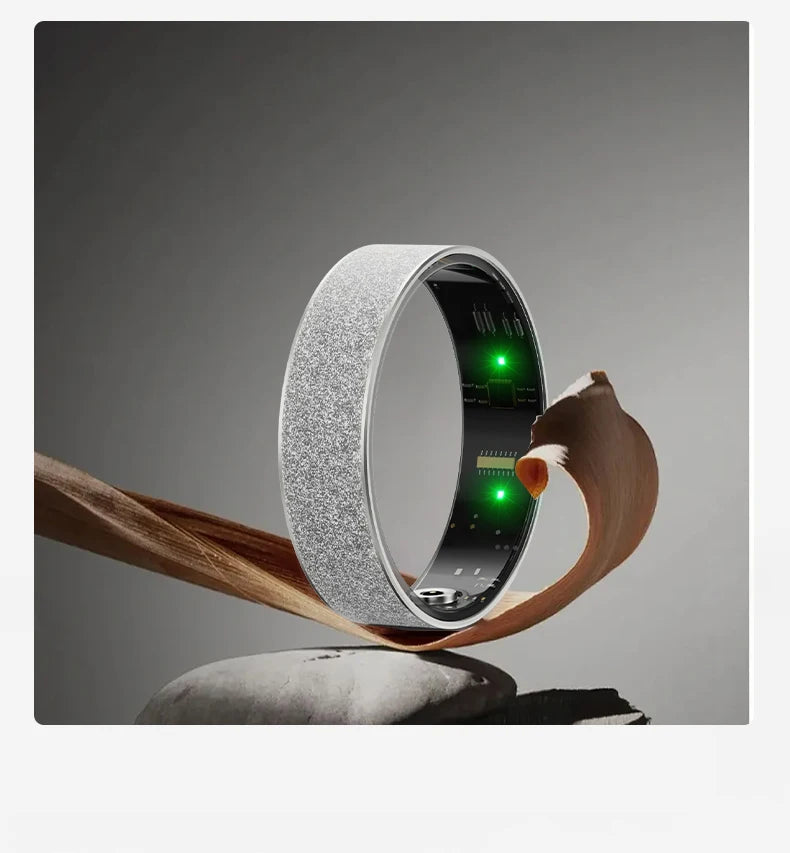Silver textured health tracker ring held above rocks with green LED indicator lights