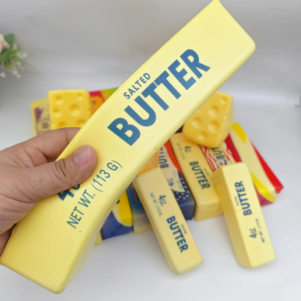 Squishy butter stick fidget toy, hand holding yellow salted butter bar with blue logo