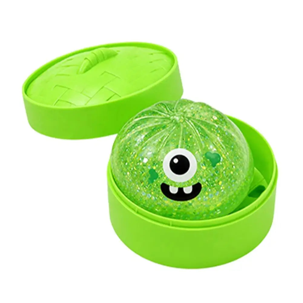 Green glitter squishy bun stress ball in lime round case, big-eye monster smile