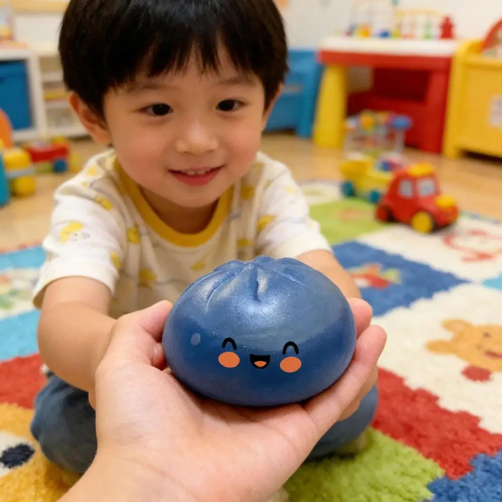 Blue glitter squishy dumpling stress ball with smiling face, held in a hand