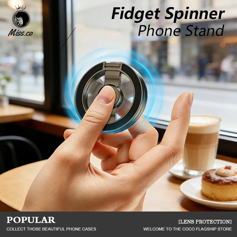 Silver magnetic fingertip phone stand with ring spinner, held in a hand