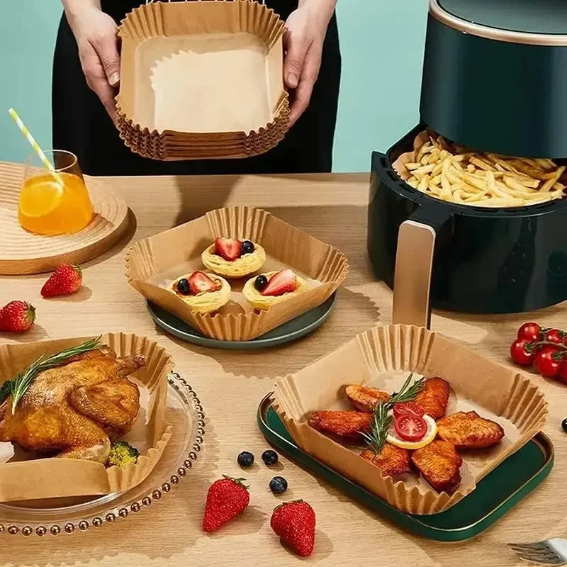 Air fryer paper liners stacked and used for pastries, with a dark air fryer nearby