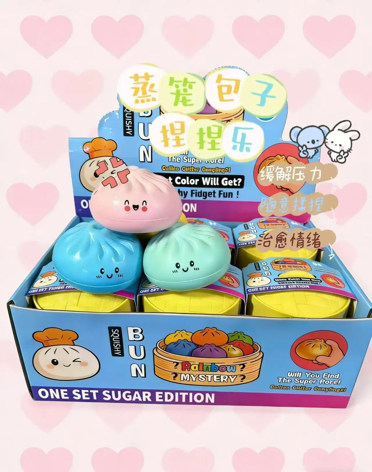 Box of dumpling squishy toys with cute faces, featuring pastel rainbow colors