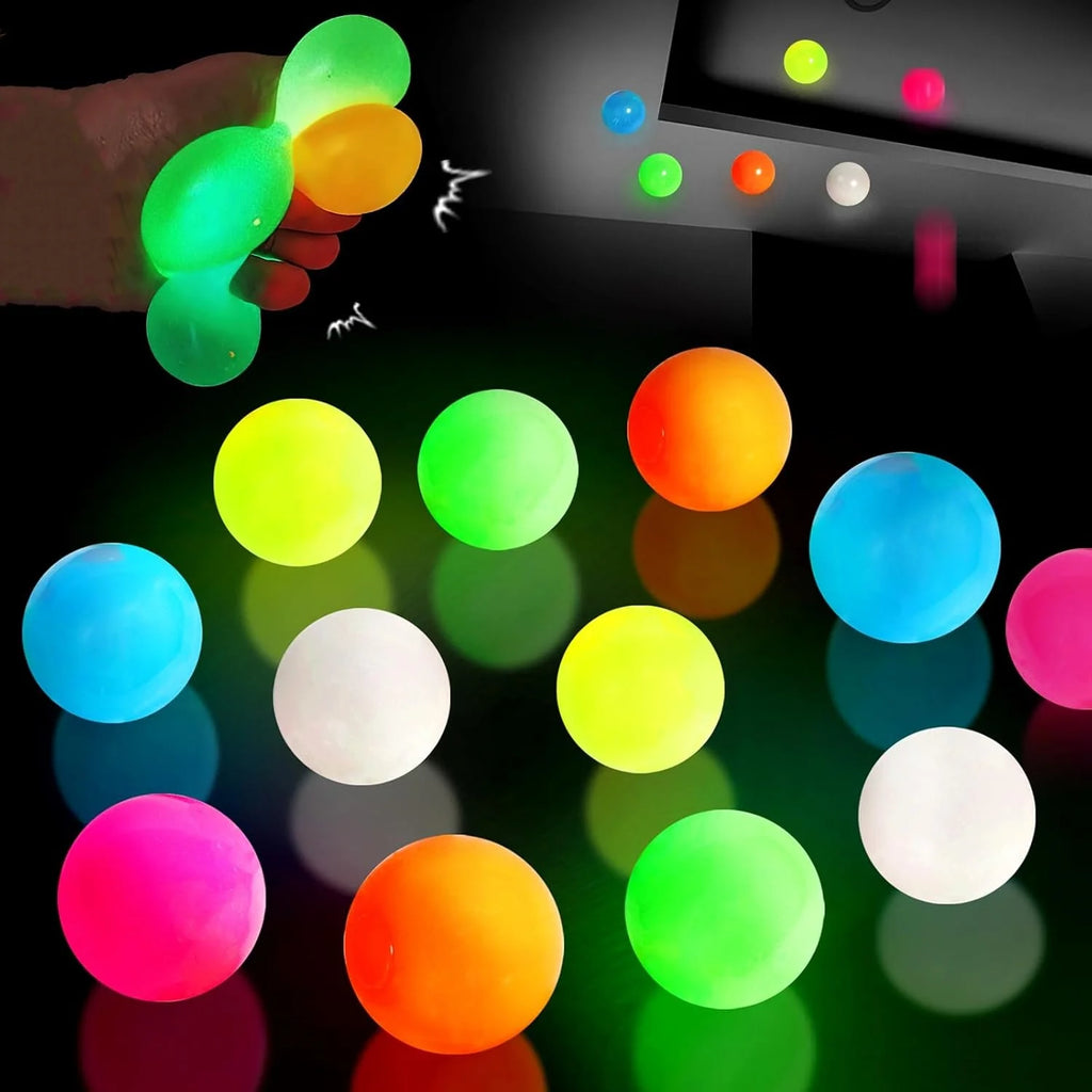 Multicolor glow sticky balls with a hand throwing or stretching them in the dark