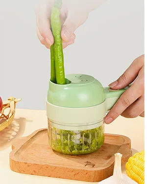 Green handheld vegetable cutter chopping green onions on a wooden tray