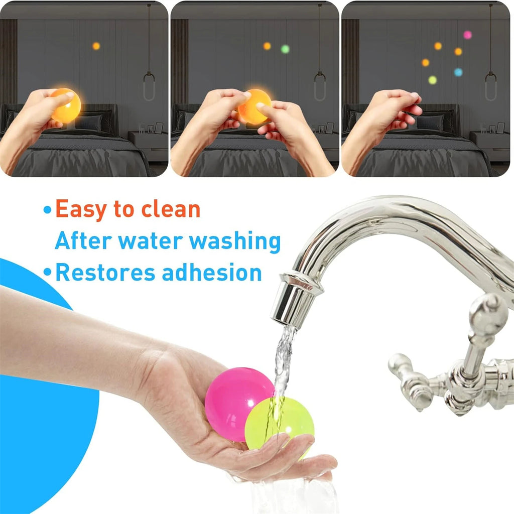 Sticky glow balls rinsed under a faucet; hand holds a pink and green ball