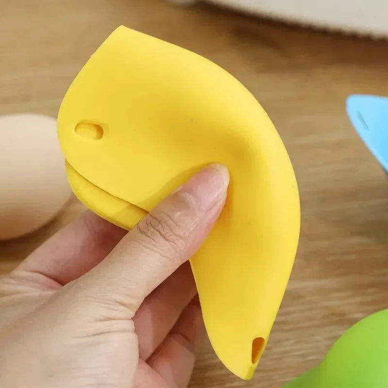Yellow silicone egg poacher cup being held by a hand