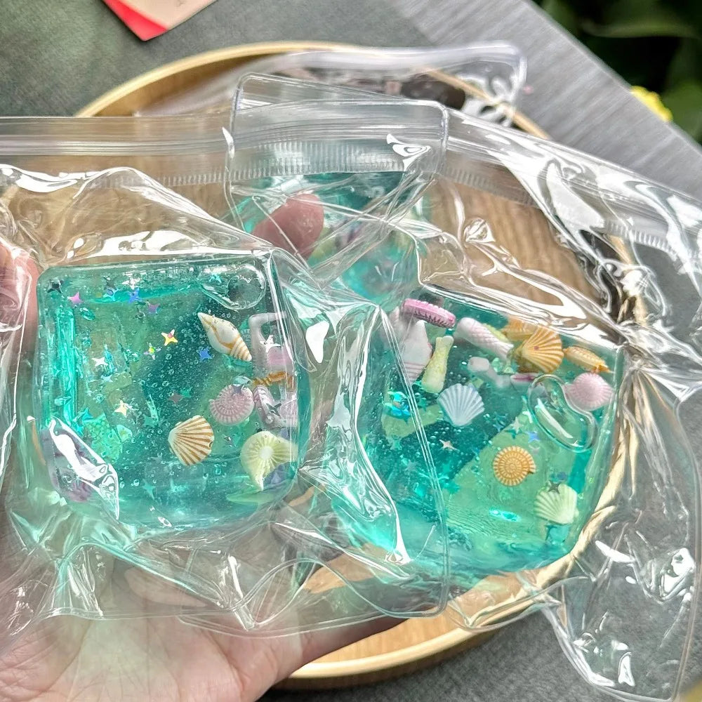 Turquoise ocean squishy stress ball cube toys in clear plastic bags, sea-creature confetti inside