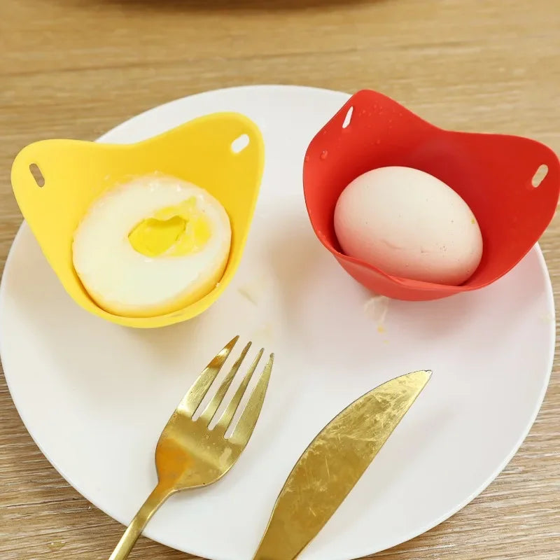 Yellow and red silicone egg poacher cups holding cooked eggs on a plate.