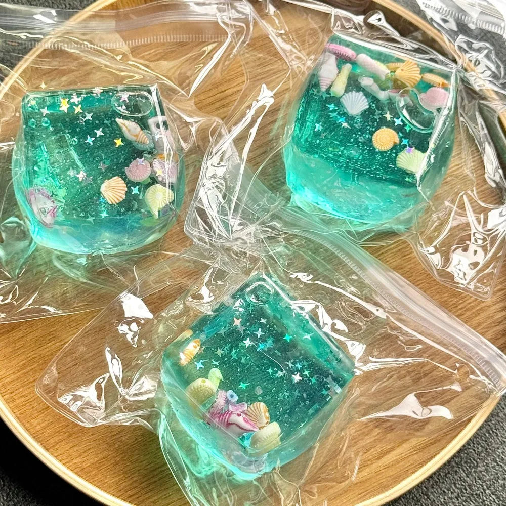 Set of turquoise ocean squishy stress ball cube toys with star and sea-creature details in clear wraps